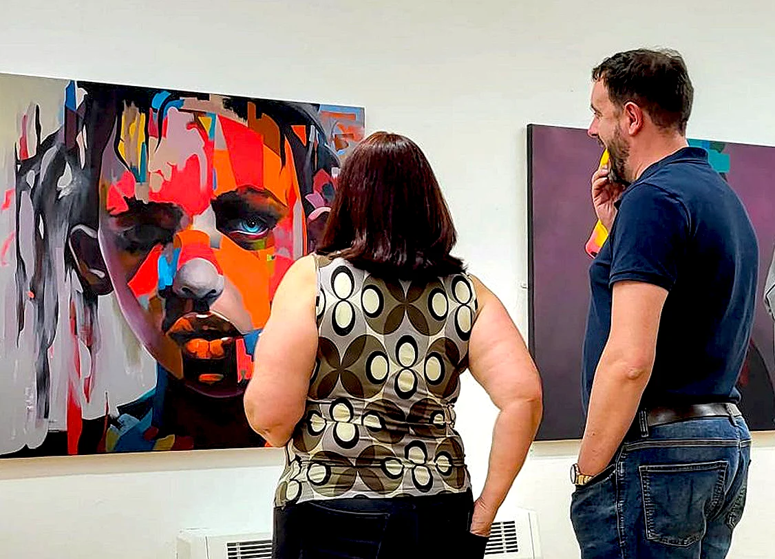 Visitors viewing abstract portrait painting ‘Strength from Within’ at solo exhibition in Peterborough Museum & Art Gallery