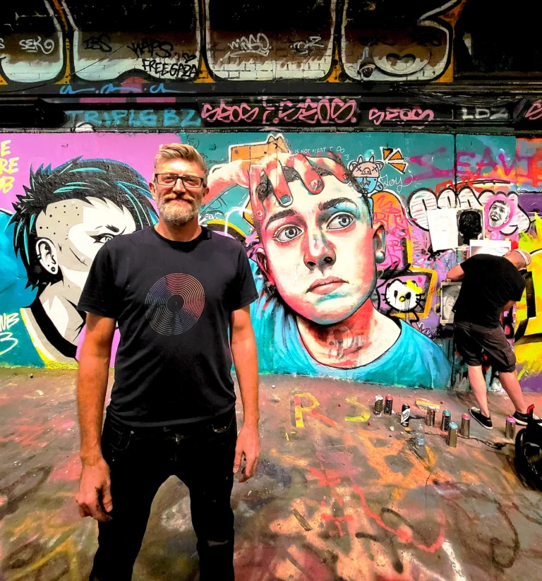 Street artist Daniel Wilson with portrait artwork at Leake Street Tunnel