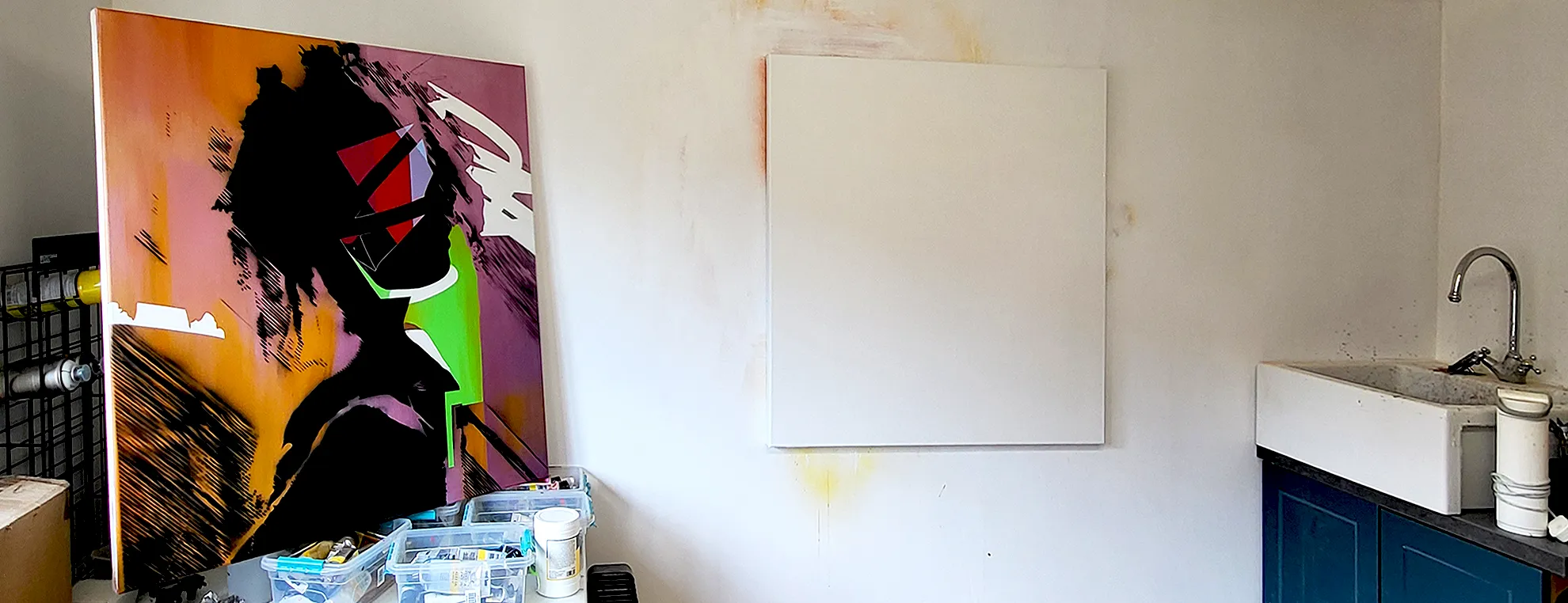 Painting beside a blank canvas in Paul Kneen's studio